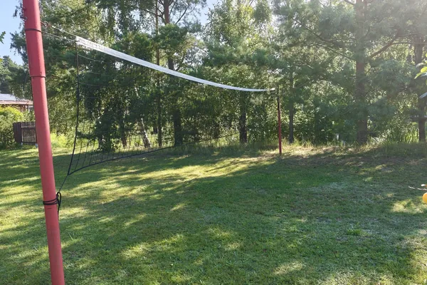 Siatka do siatkówki rozstawiona na słupkach na trawie w agroturystyce U Marianny w Mikoszewie